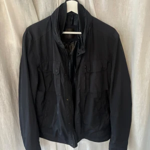Mörkblå jacka från Massimo Dutti - Säljer denna schyssta jacka från Massimo Dutti då den blivit lite för liten - Perfekt för hösten nu! Finns både många ytter - & innerfickor och luva gömd i kragen. Strl M men skulle säga att den är snäppet mindre så passar även S. Väldigt fint skick förutom ett slitage på en av knapparna vid ryggen och ett otroligt litet hål strax under, vilket inte är nått som man lägger märke till. Kom gärna med prisförslag!