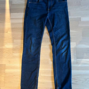 Levi's 512 Slim Taper jeans mörkblå - Säljer ett par Levi's 512 Slim Taper jeans i mörkblå tvätt med klassiska fem fickor och snygga kontrastsömmar. Modellen har smal passform med avsmalnande ben och normal midja. Perfekt för dig som gillar stilrena och moderna jeans.