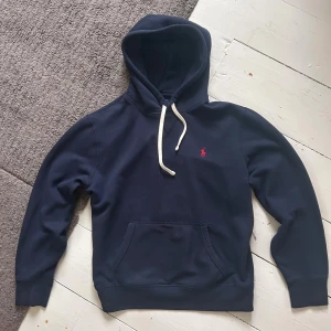 Mörkblå/Marinblå Ralph Lauren Hoodie - Riktigt fet matimblå Ralph Lauren hoodie perfekt nu till kyligare dagar i vinter! | Storlek: M, passar även nästan S | Nypris: 2230kr | Riktigt fint skick, pyttelite urtvättad, men absolut inget man anmärker. | Skriv vid minsta fundering, priset är ej hugget i sten!