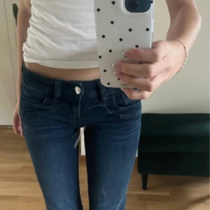 Lågmidjade jeans från Gina Tricot - Snygga mörkblå jeans från Gina Tricot med låg midja och utsvängda ben. Storlek 152 men passar mig som har xs, nersprättade längst nere ❣️