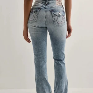 True religion med hål - Säljer ett par ljusblå jeans från True Religion med bootcut passform och snygga slitningar på knäna. De är i storlek W27 och är endast använda 2 gånger och i ett utmärkt skick. Nypris 1300kr❣️
