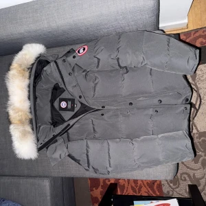 Canada Goose Grå Wyndham  - Säljer en grå dunjacka från Canada Goose Red Label. Sjukt fet jacka med bra dun fyllning. Dunder passform. Passar från 175-183cm. Säljer för vill ha en svart wyndham med black label istället. DM för fler frågor osv. Pris kan diskuteras, vill sälja så fort som möjligt.🪿🪶🇨🇦