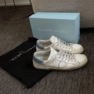 Philippe Model vita sneakers med blå detaljer - Tja! Säljer nu dessa feta philippe model skorna! Riktigt sköna och stilrena skor. Skick 7/10 Hör av er med minsta frågor! Skickar inom 24h📦