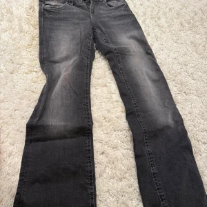 Grå jeans med broderade bakfickor Gina Tricot - Snygga grå jeans från Gina Tricot i storlek 164. Modellen har raka ben och broderade detaljer på bakfickorna som ger en unik touch. Jeansen har klassisk femficksdesign och är tillverkade i mjukt jeanstyg.