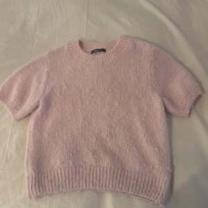 Ljusrosa stickad tröja Gina Tricot - Supermysig ljusrosa stickad tröja från Gina Tricot med korta ärmar och rund hals. Köptes för ungefär 300 kr. Har ett litet hål vid den vänstra axeln men går att sy ihop. Har haft tröjan i 1 år men den har bara använts några gånger