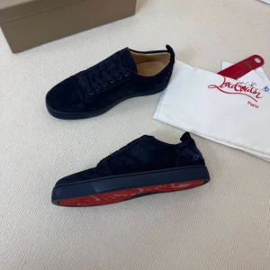 Mörkblå sneakers från Louboutin - Snygga mörkblå sneakers från Louboutin i mocka med klassisk röd sula och diskret logga på hälen. Skorna har rund tå, platt sula och snörning. Perfekta för dig som vill ha en lyxig och stilren look med en ikonisk touch.