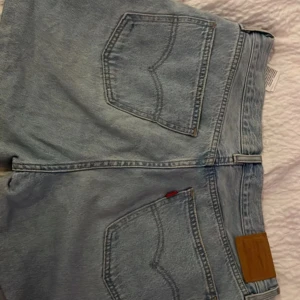 Levi's Premium ljusblå jeansshorts - Säljer ett par snygga ljusblå jeansshorts från Levi's Premium. Klassisk femficksmodell med dragkedja och bälteshällor. Shortsen är i bomull och har den ikoniska Levi's-detaljen på bakfickan. Perfekta för en chill sommarstil. OPS! De är klippta o sydda till short hemma själv.