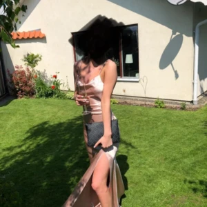 Ljusrosa balklänning i satin - Säljer min vackra balklänning i ljusrosa satin med smala axelband, öppen rygg och hög slits. Klänningen har en figurnära passform och ett glansigt material som ger en lyxig känsla. Storlek 36 men klänningen är insydd och passar dig som är storlek 34 och runt 170cm plus klackar.