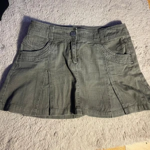 Vintage kjol  - Cool grå kjol med fickor och veck – ger en perfekt Y2K och streetstyle-look. Tjockare tyg med struktur, sitter fint i midjan. Fint skick, aldrig använd  🖤 Lätt att styla med hoodie, croptop eller boots för en edgy vibe.