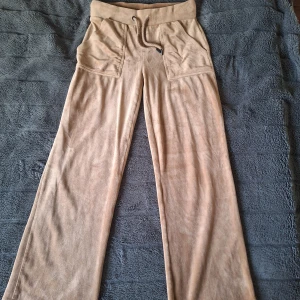 Beige mjukisbyxor (Juicy dope från lager 157) - Snygga beige mjukisbyxor med bred resår och snörning i midjan. Byxorna har stora fickor fram och bak, raka ben och är gjorda i ett mjukt, fleeceliknande material som känns skönt mot huden. Perfekta för chill eller häng med kompisar.