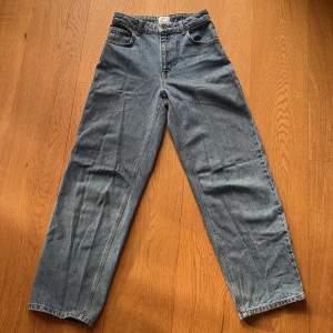 Blå wide jeans från Grunt - Säljer ett par blå jeans från Grunt, modell Ourganic. Byxorna har en rak och bred passform med klassiska fem fickor och hög midja. Jeansen är tillverkade i jeansmaterial och har en snygg ljusblå tvätt. Perfekt för dig som gillar en avslappnad och trendig look.