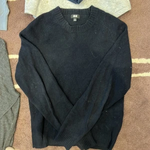 Svart stickad tröja från Uniqlo - Tvärfet svart tröja från Uniqlo i mjuk ull/kashmir. Klassisk rund halsringning och långärmad modell, perfekt för lager på lager. Enkel och stilren design som funkar till allt.  Säljes i storlek S.👊🔥