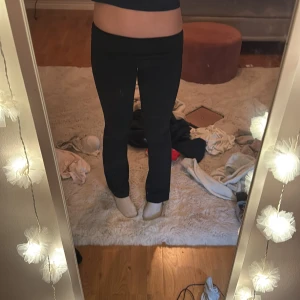 Svarta bootcut byxor med låg midja - Säljer ett par svarta byxor med snygg bootcut och låg midja. De har en smickrande passform som sitter tight över låren och släpper ut vid vaden. Perfekta för dig som gillar en klassisk och stilren look. Materialet är mjukt och stretchigt för extra komfort.