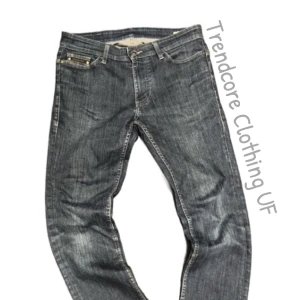 Calvin Klein Jeans - Snygga Calvin Klein jeans i mörkblå tvätt med klassisk femficksdesign och coola detaljer på bakfickorna. Jeansen har raka ben och normal passform, tillverkade i slitstarkt denim med ljusa kontrastsömmar. Perfekt för dig som gillar stilrena jeans med lite edge. I storlek 29/30