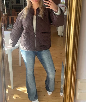 Quiltad brun jacka med dragkedja - Säljer en quiltad brun jacka med dragkedja framtill och stora fickor. Jackan har en loose passform och är i storlek 34 men passar xs-L