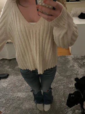 Beige ribbad stickad tröja v-ringad - Säljer en beige stickad tröja med ribbad struktur och v-ringad hals. Tröjan har en loose passform och långa ärmar🥰🥰