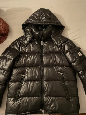 Svart Moncler pufferjacka med NFC - Svart pufferjacka från Moncler med glansig finish, Size L, Har NFC och är inte använd så ofta