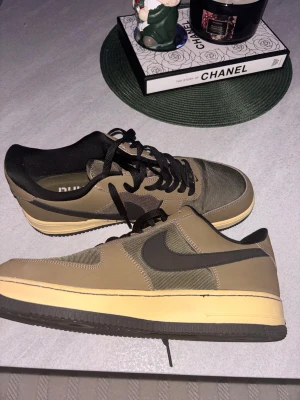 Nike Air Force 1 Undefeated olive(Limited edition) -  Nike Air Force 1 Undefeated sneakers i olivgrön och beige med svarta detaljer. Låg modell med svart swoosh, snörning och Undefeated-logga på sidan. Ovandel i syntet och mesh, platt sula i beige och svart. Perfekt för dig som gillar streetwear och unika collabs. Oanvända!