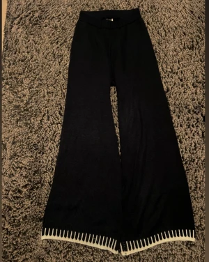 Mörkblå sköna byxor - Mörkblå byxor med breda ben och vit dekorativ kant längst ner. Mjukt material 