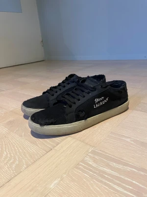  Saint Laurent skor - Svarta sneakers från Saint Laurent. De är äkta men väl använda. De har blivit lagade (båda hälarna se bild) och städade. Men de ser väldigt fräscha ut. (En sko har utbytt sula inuti) Priset går alltid att diskutera!💪