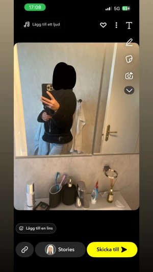 Svart teddyjacka med bälte - Säljer en svart teddyjacka med dragkedja framtill och snyggt bälte i midjan. Jackan har hög krage och en lite boxig passform, perfekt för att hålla värmen och se cool ut. Passar dig som gillar en stilren och trendig look.