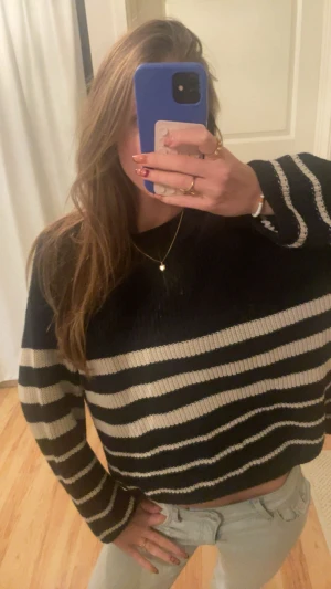 Randig svartvit stickad tröja - Säljer en stickad tröja med breda svarta och vita ränder. Tröjan har en avslappnad passform, rund halsringning och långa ärmar. Perfekt för dig som gillar en chill och stilren look.