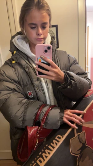 Grön pufferjacka från Fjällräven - Säljer min grå pufferjacka från Fjällräven med ikonisk röd logga på bröstet. Jackan har en stor huva, dragkedja och knappar framtill samt coola gula detaljer vid axlarna. Perfekt för dig som vill ha en varm och snygg jacka med loose fit. Det är modellen expedition down. Storlek xs men är som en s