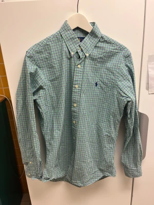 Ralph Lauren Rutig Skjorta Storlek M Slim Fit - Hej! Säljer nu denna väldigt snygga Ralph Lauren Skjortan.  Storlek Medium Slim Fit  Färg: Grön, blå och vit Skick: Mycket gott – endast använd vid enstaka tillfällen  Skickas spårbart eller hämtas upp efter överenskommelse. Vid intresse – hör gärna av dig.  Skriv vid frågor eller ifall du vill ha fler bilder:) 