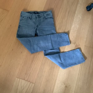  Helt nya Jack & Jones jeans – Storlek 28/30  - Säljer ett par helt nya och aldrig använda jeans från Jack & Jones. Jeansen är i färgen grå, en stilren och mångsidig färg som passar till det mesta – perfekt för både vardag och mer uppklädda tillfällen.  ✨ Detaljer: 	•	Märke: Jack & Jones 	•	Storlek: 28/30 	•	Skick: Nytt skick (aldrig använda) 	•	Färg: Grå  👕 Passar utmärkt till både t-shirt och sneakers för en avslappnad look, eller till skjorta och kavaj för en mer dressad outfit.  📦 Snabb lev