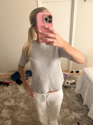 Ljusgrå stickad kortärmad tröja - Supermjuk ljusgrå stickad tröja med korta ärmar och rund hals. Enkel och clean look som är lätt att matcha med allt. Perfekt för dig som gillar minimalistisk stil och vill ha något bekvämt men ändå snyggt.