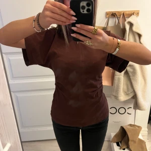 Topp med insydd midja från Zara - Säljer denna topp från Zara med insydd midja i en mörkröd, snygg färg. Toppen har en markerad söm framtill och är figurnära i modellen. 