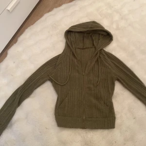 Snygg, kort kofta!! - En grön/olivgrön tröja som har ungefär storlek xs/s. Vet ej från vart!! Den är snygg, kort och passar perfekt för lowaist jeans.