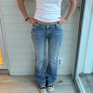 Ljusblå bootcut jeans  - Ljusblå lågmidjade jeans i storlek XS. Midja: 37-38x2 cm innerben: 84 cm. Har en ljusgul missfärgning på ena benet, se sista bilden 