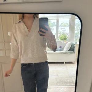 Beige stickad tröja med krage - En så fin beige stickad tröja med snygg krage och v-ringning. Tröjan har trekvartsärm och ribbad kant nedtill!