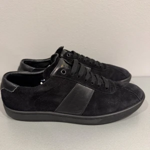 Svarta sneakers från Saint Laurent - Svarta sneakers från Saint Laurent i mocka och skinn. Rätt bra skick, endast skorna medföljer. Storlek 42/43 Hör av er vid frågor eller funderingar. 