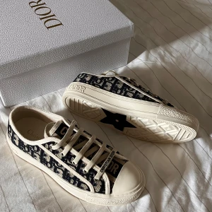 Christian Dior Oblique sneakers beige/marin - PRIS GÅR ATT DISKUTERAS, Snygga Dior Oblique sneakers i beige och marinblått med ikoniskt monogrammönster. Skorna har snörning, rund tå och platt sula med stjärndetalj undertill. Tillverkade i canvas med detaljer i gummi och textil. Perfekta för dig som vill sticka ut med lyxig streetstyle.
