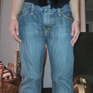 Blåa jeans från J.Lindeberg Denim - Säljer ett par klassiska blå jeans från J.Lindeberg Denim med raka ben och snygga kontrastsömmar. Jeansen har normal midja, fem fickor och coola detaljer på bakfickorna. 