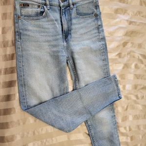 Polo Ralph Lauren skinny jeans ljusblå size 27 - Ljusblå skinny jeans från Polo Ralph Lauren, modell Tompkins High Rise Ankle. Hög midja, ankellängd och råa kanter nertill. Klassisk femficksdesign och mjukt denimtyg som sitter tight hela vägen ner.