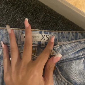 Ljusblå jeansbyxor från Sisters XS - Säljer ett par ljusblå jeansbyxor från Sisters i storlek XS. De har klassisk femficksdesign, bälteshällor och raka ben med lite avslappnad passform. Perfekta till sneakers eller boots för en chill look.