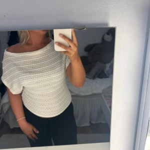 Vit stickad topp från Nelly - Säljer en vit stickad topp från Nelly i storlek S. Toppen har en snygg offshoulder-design och är tillverkad i ett mjukt stickat material med struktur. Perfekt för dig som gillar en chill och trendig look med lite extra detaljer i stickningen. (Ny utan prislapp.)