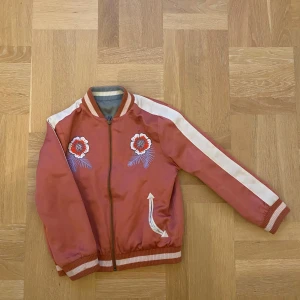 Stella MC jacka för barn - En super fin Stella jacka i tyg som man kan vända ut och in på och få en till jacka!!!! En helt ny färg och med ett super fint tryck på baksidan. Den är i storlek 10 år BARN