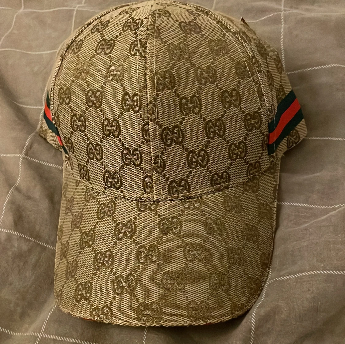 Beige keps med GG-mönster och ränder