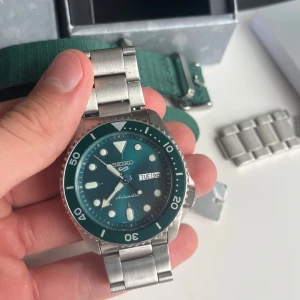 Seiko 5 Sports automatisk klocka  - Säljer en Seiko 5 Sports automatisk klocka med grön urtavla och vridring. Kloxkan är i absolut toppskick, använd cirkus 1 månad 9/10. Nyårs runt 3700kr men säljs nu för 1899kr. Hör av er vid funderingar! Har allt OG samt extra länkar och band.