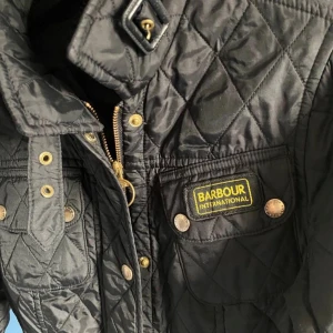 Svart quiltad jacka från Barbour - Säljer en snygg svart quiltad jacka från Barbour International. Storlek xs men sitter som en small. Jackan har en klassisk design med dragkedja och knappar framtill. Den har långa ärmar och flera praktiska fickor. Perfekt för en stilren look. Nypris 3000. Ta denna och en Massimo dutti strl M för endast 599kr!! Nypris på båda dessa är ungefär 5000 ta chansen nu, bara skriva vid funderingar