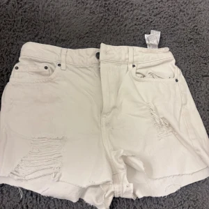 Vita denimshorts från Zara Woman - Vita denimshorts från Zara Woman i relaxed fit . Shortsen har slitna detaljer framtill, råa kanter och klassiska fem fickor. 