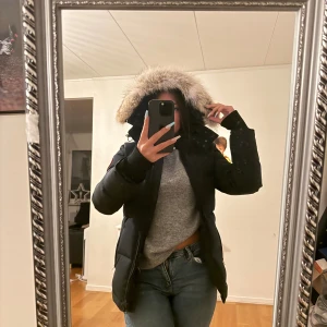 Mörkblå Canada Goose med päls - Säljer en mörkblå jacka från Canada Goose med avtagbar päls. Jackan har inga slitningar sitter fint runt midjan och den är helt ny bara använd en gång, säljer för den är lite för liten på mig. Jättevarmt o skön. Skriv för pris osånt💕