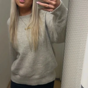 Beige stickad tröja  - Mysig beige stickad tröja med rund hals och lång ärm. Tröjan har en loose passform och är perfekt för lager-på-lager. Enkel och stilren design som passar till allt.