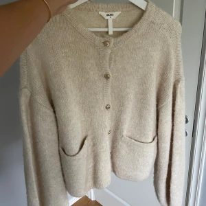 Beige stickad kofta - Supermysig beige stickad kofta från Object med snygga guldknappar framtill och två stora fickor. Nypris 899kr och aldrig använd!