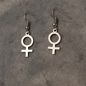 Feminist örhängen silver imitation kvinnosymbolen - 10% av det här köpet ger jag till kvinnojouren Karlskrona.   Fina örhängen med kvinnosymbolen. Silverimitation.  
