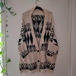Beige och svart kofta från Monki - Härlig cardigan i bohem-style. Oversized och draperas sjukt snyggt över axlar och hela kroppen. Mått: Längd och totalbredd är båda 80 cm (har passat mig superbra, men kommer passa någon som är upp till XL skulle jag säga